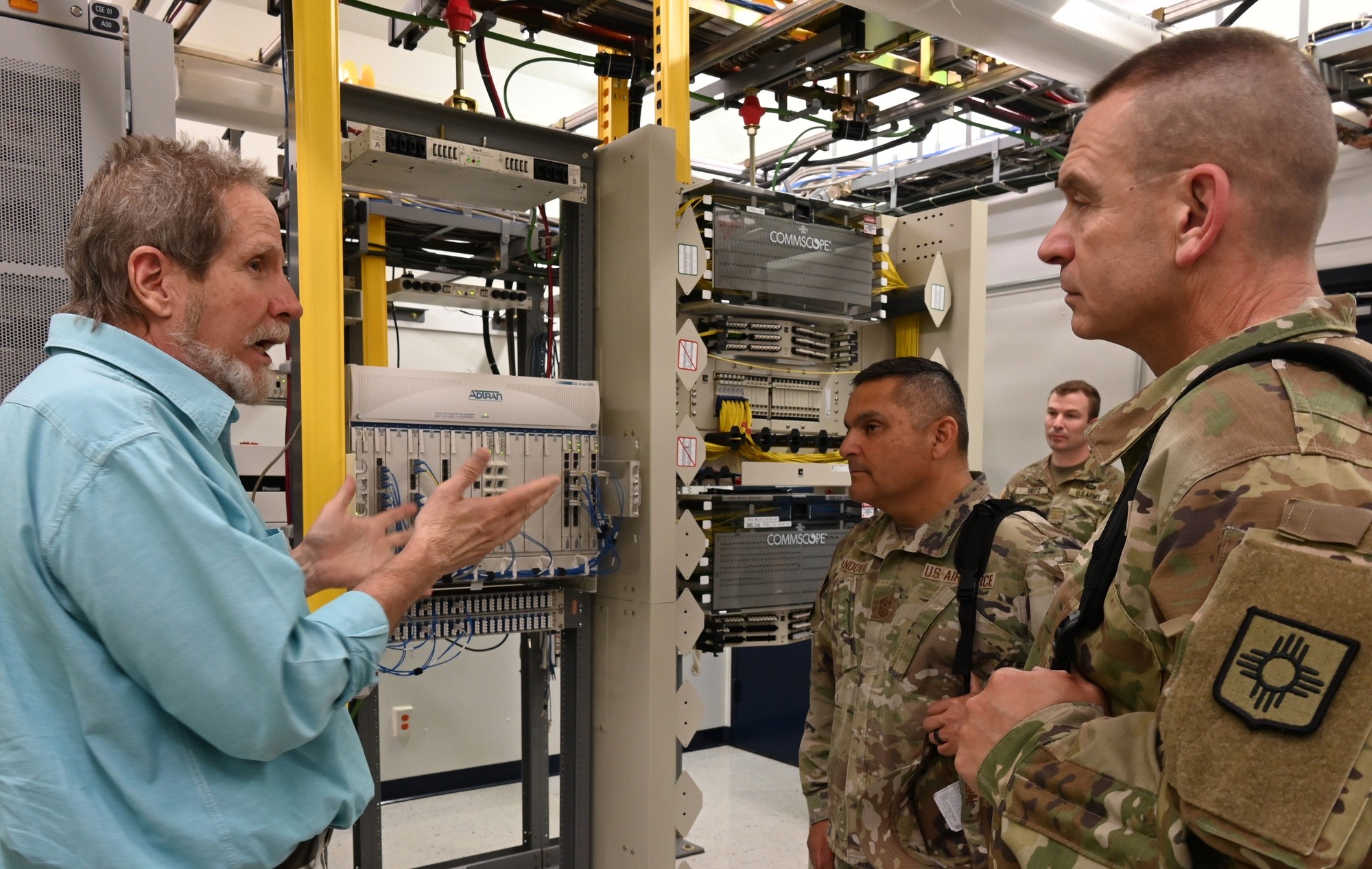 Mescalero Apache Telecom staff discuss communications equipment with National Guard cyber specialists.
