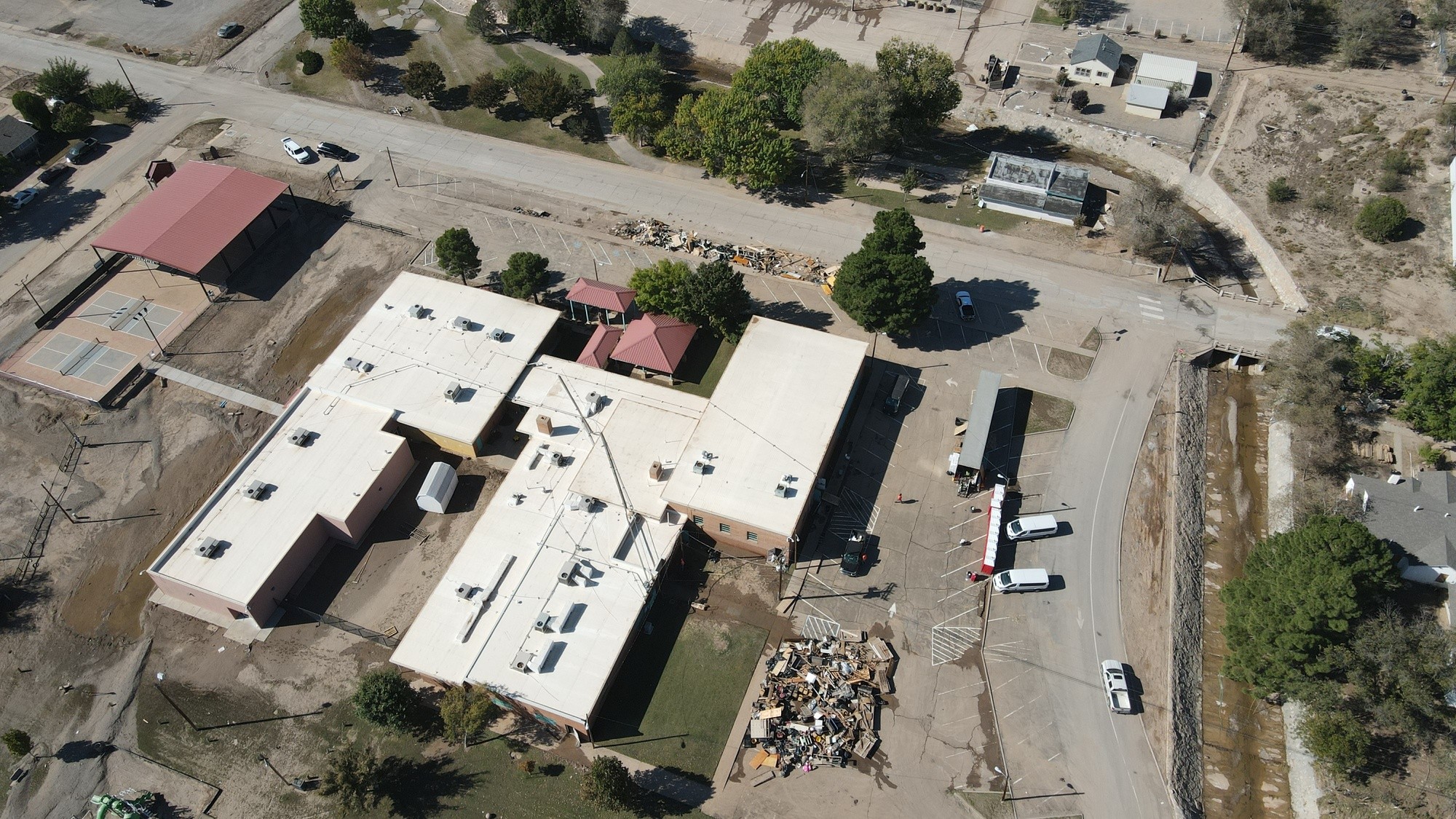 Aerial view of flood cleanup around a building and nearby roads in Roswell.