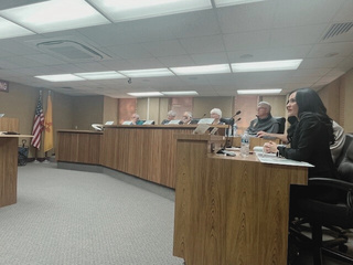 Participants speaking and listening at a public hearing.